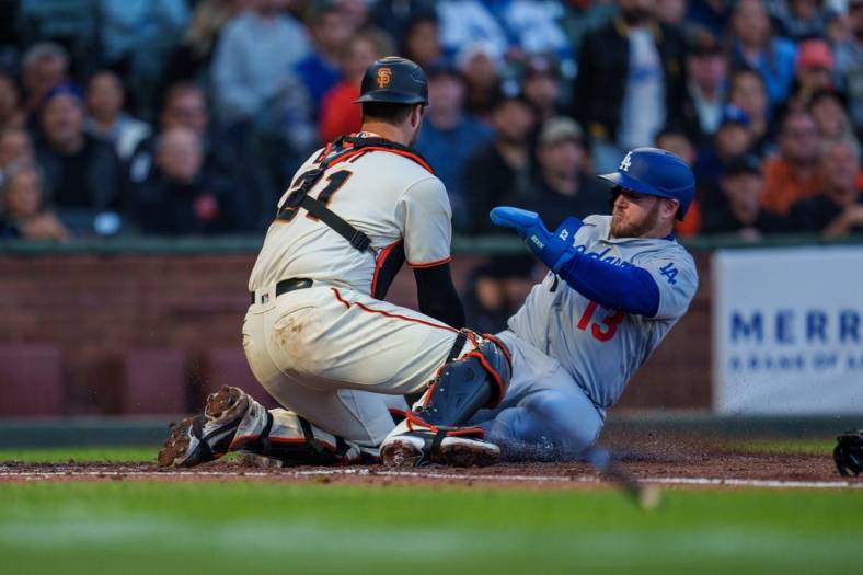 Aug 3, 2022; San Francisco, California, USA;  Los Angeles Dodgers third baseman Max Muncy (13) slides in safely against San Francisco Giants catcher Joey Bart (21) during the fourth inning at Oracle Park. Mandatory Credit: Neville E. Guard-USA TODAY Sports