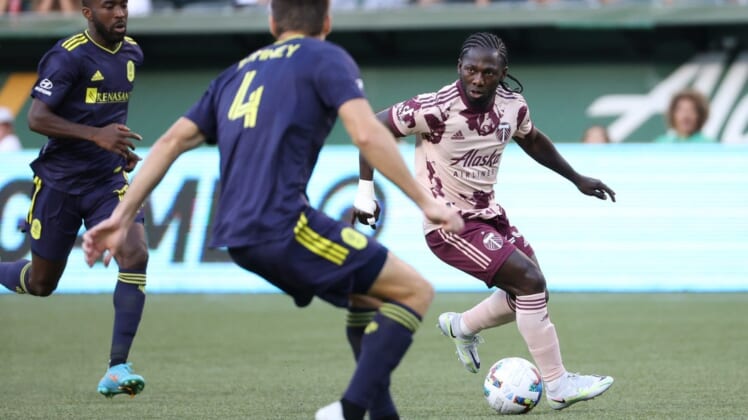 Aug 3, 2022; Portland, Oregon, USA; Portland Timbers forward Yimmi Chara (23) looks to passes the ball against Nashville SC defender Dave Romney (4) during the first half at Providence Park. Mandatory Credit: Jaime Valdez-USA TODAY Sports