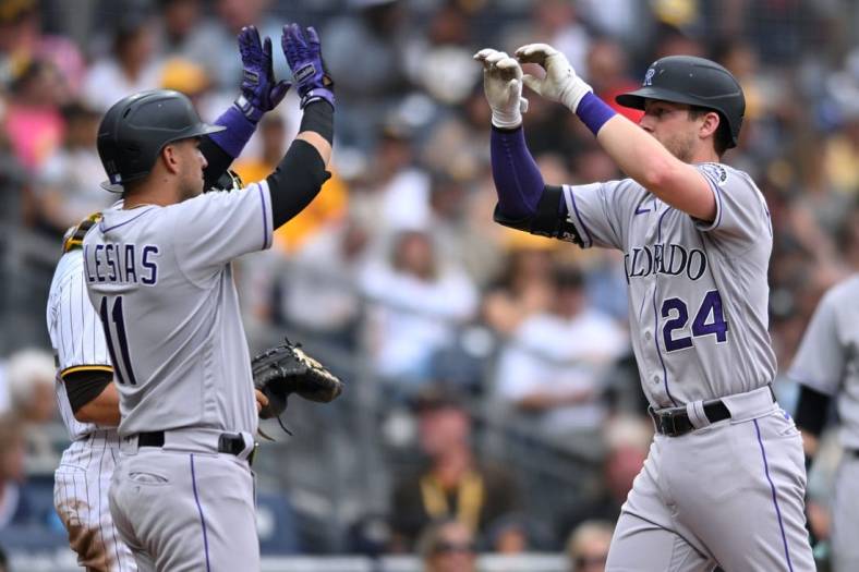 Aug 4, 2022; San Diego, California, USA; Colorado Rockies second baseman Ryan McMahon (24) is congratulated by designated hitter Jose Iglesias (11) after hitting a three-run home run against the San Diego Padres during the fifth inning at Petco Park. Mandatory Credit: Orlando Ramirez-USA TODAY Sports