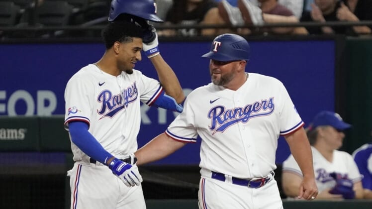 Aug 4, 2022; Arlington, Texas, USA; Texas Rangers left fielder Bubba Thompson (65) is congratulated by first base coach Corey Ragsdale (64) after bunting for his first MLB hit during the seventh inning against the Chicago White Sox at Globe Life Field. Mandatory Credit: Raymond Carlin III-USA TODAY Sports