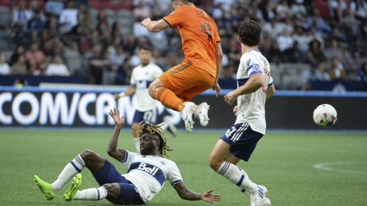 Aug 5, 2022; Vancouver, British Columbia, CAN;  Houston Dynamo FC forward Sebastian Ferreira (9) jumps over Vancouver Whitecaps FC midfielder Leonard Owusu (17) during the first half at BC Place. Mandatory Credit: Anne-Marie Sorvin-USA TODAY Sports
