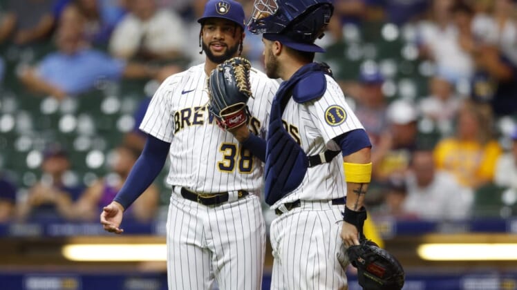 Aug 5, 2022; Milwaukee, Wisconsin, USA;  Milwaukee Brewers pitcher Devin Williams (38) talks with catcher Victor Caratini (7) during the ninth inning against the Cincinnati Reds at American Family Field. Mandatory Credit: Jeff Hanisch-USA TODAY Sports