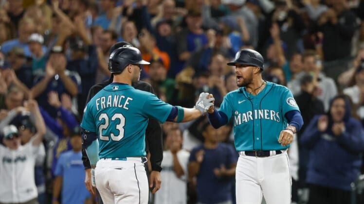 Aug 5, 2022; Seattle, Washington, USA; Seattle Mariners first baseman Ty France (23) celebrates with first base coach Kristopher Negron (45) after hitting a two-run single against the Los Angeles Angels during the ninth inning at T-Mobile Park. Mandatory Credit: Joe Nicholson-USA TODAY Sports