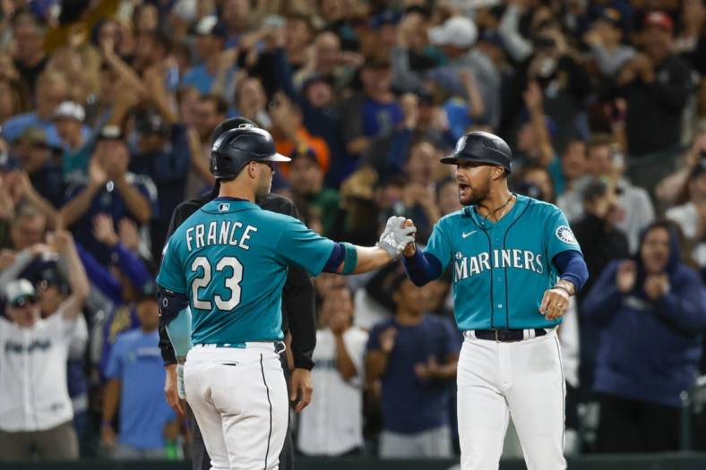 Aug 5, 2022; Seattle, Washington, USA; Seattle Mariners first baseman Ty France (23) celebrates with first base coach Kristopher Negron (45) after hitting a two-run single against the Los Angeles Angels during the ninth inning at T-Mobile Park. Mandatory Credit: Joe Nicholson-USA TODAY Sports