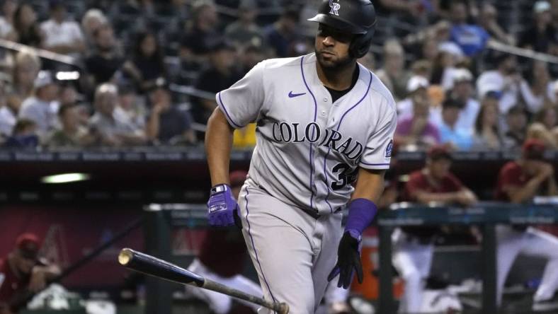 Aug 7, 2022; Phoenix, Arizona, USA; Colorado Rockies catcher Elias Diaz (35) tosses his bat after drawing a walk against the Arizona Diamondbacks in the sixth inning at Chase Field. Mandatory Credit: Rick Scuteri-USA TODAY Sports