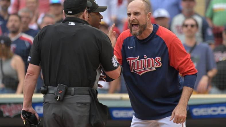 Aug 7, 2022; Minneapolis, Minnesota, USA; Minnesota Twins manager Rocco Baldelli (5) reacts with umpire Marty Foster (60) and umpire Alan Porter (64) to an overturned call during the tenth inning at Target Field. Mandatory Credit: Jeffrey Becker-USA TODAY Sports