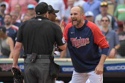 Aug 7, 2022; Minneapolis, Minnesota, USA; Minnesota Twins manager Rocco Baldelli (5) reacts with umpire Marty Foster (60) and umpire Alan Porter (64) to an overturned call during the tenth inning at Target Field. Mandatory Credit: Jeffrey Becker-USA TODAY Sports