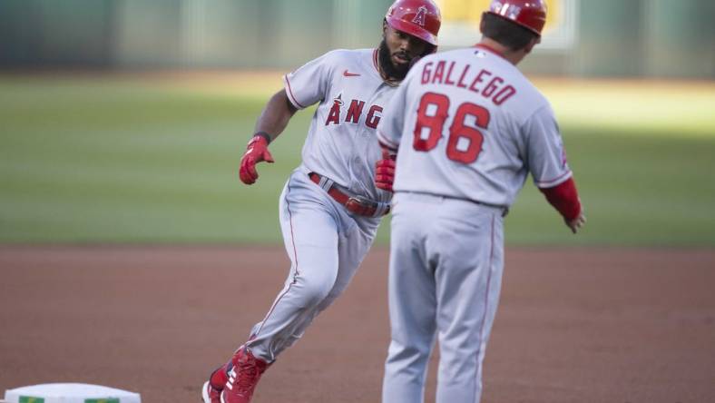 Aug 8, 2022; Oakland, California, USA; Los Angeles Angels second baseman Luis Rengifo (left) is greeted by third base coach Mike Gallego (86) after hitting a solo home run during the first inning at RingCentral Coliseum. Mandatory Credit: D. Ross Cameron-USA TODAY Sports