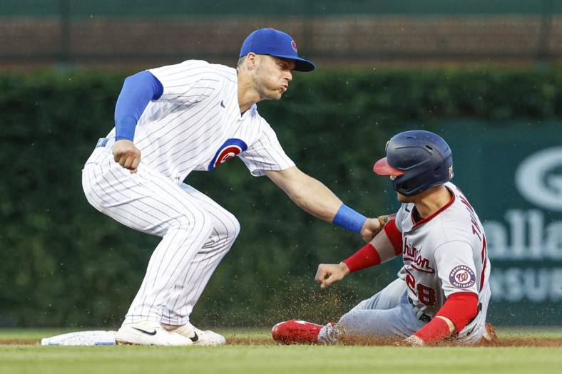 Aug 9, 2022; Chicago, Illinois, USA; Washington Nationals left fielder Lane Thomas (28) is caught stealing second base by Chicago Cubs shortstop Nico Hoerner (2) during the second inning at Wrigley Field. Mandatory Credit: Kamil Krzaczynski-USA TODAY Sports
