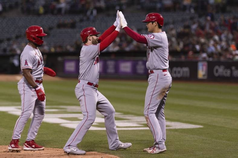 Aug 9, 2022; Oakland, California, USA;  Los Angeles Angels starting pitcher Shohei Ohtani (17) celebrates with Los Angeles Angels right fielder Taylor Ward (3) after hitting a three run homerun during the fifth inning against the Oakland Athletics at RingCentral Coliseum. Mandatory Credit: Stan Szeto-USA TODAY Sports