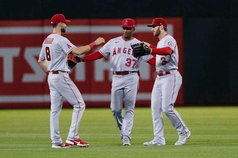 Aug 9, 2022; Oakland, California, USA;  Los Angeles Angels left fielder Steven Duggar (8) , center fielder Magneuris Sierra (37) and right fielder Taylor Ward (3) celebrate after defeating the Oakland Athletics at RingCentral Coliseum. Mandatory Credit: Stan Szeto-USA TODAY Sports