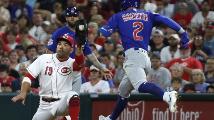 Aug 13, 2022; Cincinnati, Ohio, USA; Chicago Cubs shortstop Nico Hoerner (2) is out at first against Cincinnati Reds first baseman Joey Votto (19) during the sixth inning at Great American Ball Park. Mandatory Credit: David Kohl-USA TODAY Sports