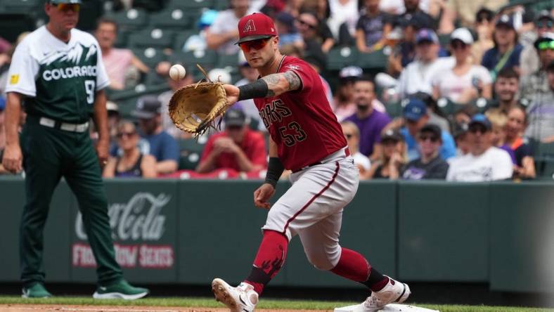 Aug 14, 2022; Denver, Colorado, USA; Arizona Diamondbacks first baseman Christian Walker (53) fields the ball in the fourth inning against the Colorado Rockies at Coors Field. Mandatory Credit: Ron Chenoy-USA TODAY Sports