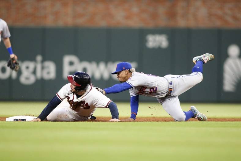 Aug 15, 2022; Atlanta, Georgia, USA; New York Mets shortstop Francisco Lindor (12) tags out Atlanta Braves catcher Travis d'Arnaud (16) at second base in the second inning at Truist Park. Mandatory Credit: Brett Davis-USA TODAY Sports
