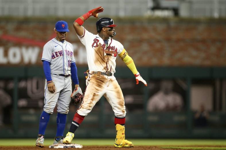 Aug 15, 2022; Atlanta, Georgia, USA; Atlanta Braves right fielder Ronald Acuna Jr. (13) celebrates after a RBI double in front of New York Mets shortstop Francisco Lindor (12) in the sixth inning at Truist Park. Mandatory Credit: Brett Davis-USA TODAY Sports