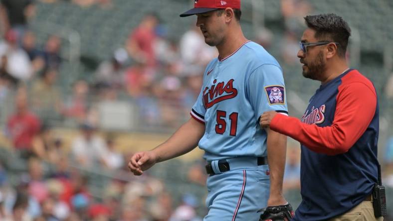 Aug 17, 2022; Minneapolis, Minnesota, USA; Minnesota Twins starting pitcher Tyler Mahle (51) comes off the field with the team trainer during the third inning against the Kansas City Royals at Target Field. Mandatory Credit: Jeffrey Becker-USA TODAY Sports