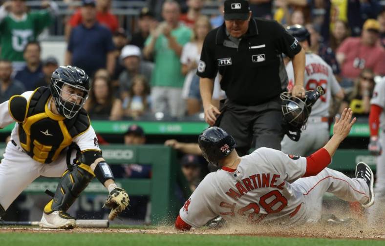 Aug 17, 2022; Pittsburgh, Pennsylvania, USA;  Boston Red Sox designated hitter J.D. Martinez (28) slides into home to score a run as Pittsburgh Pirates catcher Jason Delay (61) attempts a tag during the second inning at PNC Park. Mandatory Credit: Charles LeClaire-USA TODAY Sports
