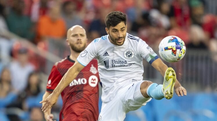 Aug 17, 2022; Toronto, Ontario, CAN; New England Revolution midfielder Carles Gil (10) attempts to control the ball against Toronto FC midfielder Michael Bradley (4) during the first half at BMO Field. Mandatory Credit: Kevin Sousa-USA TODAY Sports