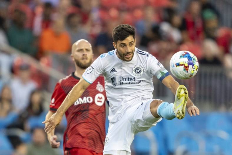 Aug 17, 2022; Toronto, Ontario, CAN; New England Revolution midfielder Carles Gil (10) attempts to control the ball against Toronto FC midfielder Michael Bradley (4) during the first half at BMO Field. Mandatory Credit: Kevin Sousa-USA TODAY Sports