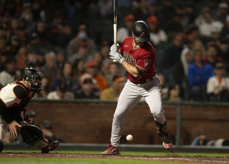 Aug 17, 2022; San Francisco, California, USA; Arizona Diamondbacks catcher Cooper Hummel (21) is hit by a pitch from San Francisco Giants starting pitcher Carlos Rod  n during the sixth inning at Oracle Park. Mandatory Credit: D. Ross Cameron-USA TODAY Sports