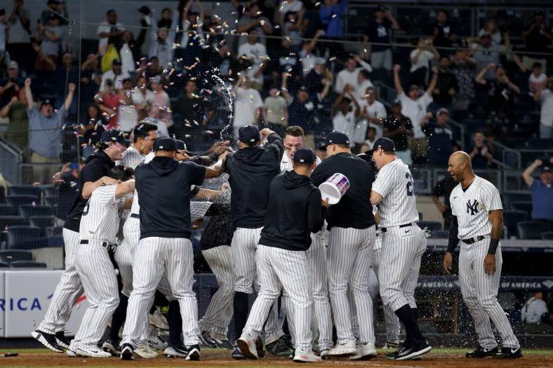 Aug 17, 2022; Bronx, New York, USA; New York Yankees designated hitter Josh Donaldson (not pictured) is met at home by teammates after hitting a game winning grand slam home run against the Tampa Bay Rays during the tenth inning at Yankee Stadium. Mandatory Credit: Brad Penner-USA TODAY Sports