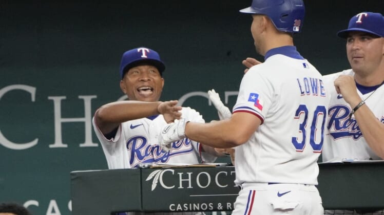 Aug 18, 2022; Arlington, Texas, USA; Texas Rangers first baseman Nathaniel Lowe (30) is congratulated by interim manager Tony Beasley (27) as he arrives to the dugout after hitting a three-run home run against the Oakland Athletics during the fifth inning at Globe Life Field. Mandatory Credit: Jim Cowsert-USA TODAY Sports