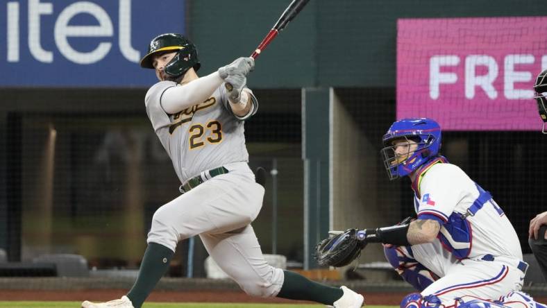 Aug 18, 2022; Arlington, Texas, USA; Oakland Athletics catcher Shea Langeliers (23) hits a double in front of Texas Rangers catcher Jonah Heim (28) during the seventh inning at Globe Life Field. Mandatory Credit: Jim Cowsert-USA TODAY Sports