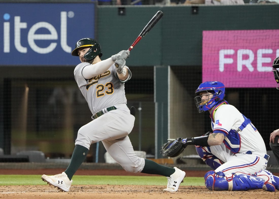 Aug 18, 2022; Arlington, Texas, USA; Oakland Athletics catcher Shea Langeliers (23) hits a double in front of Texas Rangers catcher Jonah Heim (28) during the seventh inning at Globe Life Field. Mandatory Credit: Jim Cowsert-USA TODAY Sports