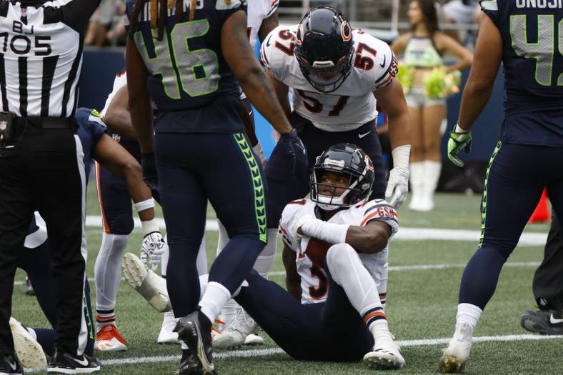 Aug 18, 2022; Seattle, Washington, USA; Chicago Bears safety Elijah Hicks (37) is helped up by teammates, including linebacker Jack Sanborn (57), after recovering a fumble for a touchdown against the Seattle Seahawks during the second quarter at Lumen Field. Mandatory Credit: Joe Nicholson-USA TODAY Sports
