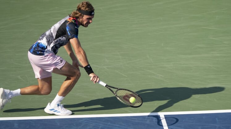 Aug 19, 2022; Cincinnati, OH, USA; Stefanos Tsitsipas (GRE) returns a shot during his match against John Isner (USA) at the Western & Southern Open at the Lindner Family Tennis Center. Mandatory Credit: Susan Mullane-USA TODAY Sports