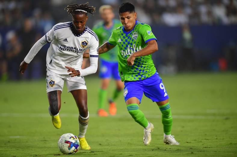 Aug 19, 2022; Carson, California, USA; Los Angeles Galaxy forward Kevin Cabral (9) plays for the ball against Seattle Sounders forward Raul Ruidiaz (9) during the first half at Dignity Health Sports Park. Mandatory Credit: Gary A. Vasquez-USA TODAY Sports