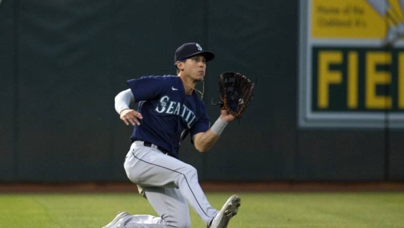 Aug 19, 2022; Oakland, California, USA; Seattle Mariners left fielder Sam Haggerty (0) makes a sliding catch against the Oakland Athletics during the fifth inning at RingCentral Coliseum. Mandatory Credit: D. Ross Cameron-USA TODAY Sports