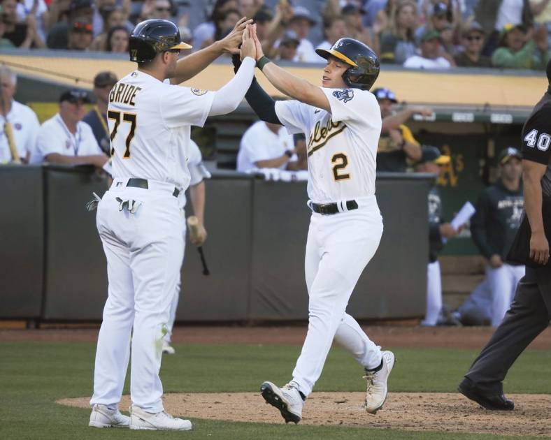 Aug 20, 2022; Oakland, California, USA; Oakland Athletics second baseman Jonah Bride (77) and shortstop Nick Allen (2) high five after being batted in against the Seattle Mariners during the fifth inning at RingCentral Coliseum. Mandatory Credit: Kelley L Cox-USA TODAY Sports