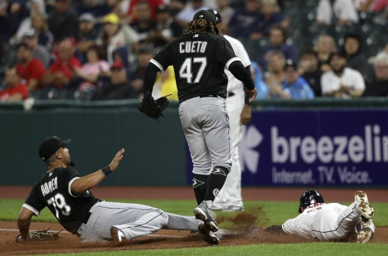 Aug 20, 2022; Cleveland, Ohio, USA; Chicago White Sox first baseman Jose Abreu (79) slides to first base to force out Cleveland Guardians Andres Gimenez (0) as pitcher Johnny Cueto jumps out of the way in the second inning at Progressive Field. Mandatory Credit: Aaron Josefczyk-USA TODAY Sports