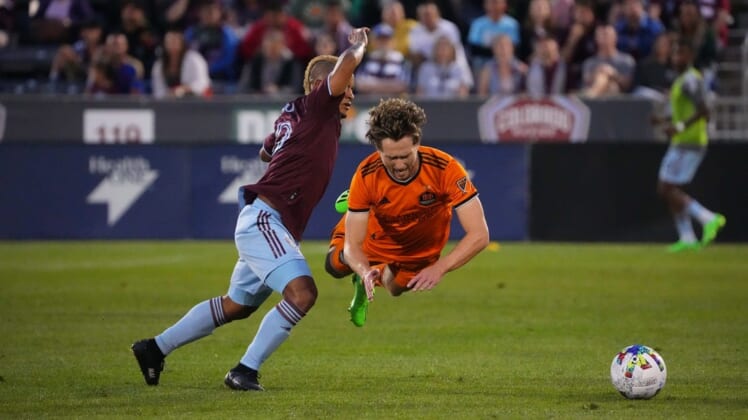 Aug 20, 2022; Commerce City, Colorado, USA; Houston Dynamo FC defender Adam Lundqvist (3) falls in front of Colorado Rapids forward Michael Barrios (12) in the first half at Dick's Sporting Goods Park. Mandatory Credit: Ron Chenoy-USA TODAY Sports