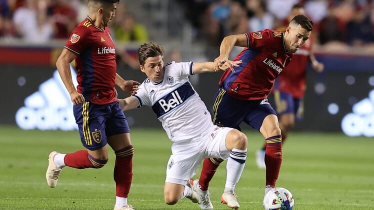 Aug 20, 2022; Sandy, Utah, USA; Vancouver Whitecaps FC midfielder Ryan Gauld (25) fights for a ball against Real Salt Lake defender Aaron Herrera (22) in the first half at Rio Tinto Stadium. Mandatory Credit: Rob Gray-USA TODAY Sports