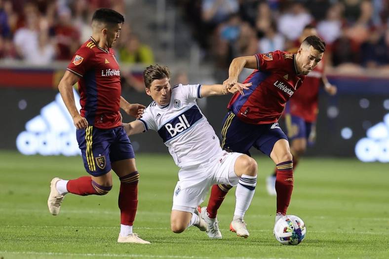 Aug 20, 2022; Sandy, Utah, USA; Vancouver Whitecaps FC midfielder Ryan Gauld (25) fights for a ball against Real Salt Lake defender Aaron Herrera (22) in the first half at Rio Tinto Stadium. Mandatory Credit: Rob Gray-USA TODAY Sports