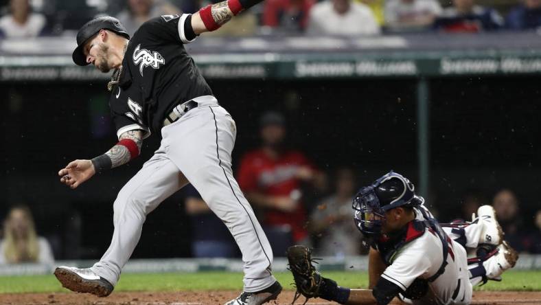 Aug 20, 2022; Cleveland, Ohio, USA; Chicago White Sox catcher Yasmani Grandal (24) is tagged out at home by Cleveland Guardians catcher Luke Maile (12) in the seventh inning at Progressive Field. Mandatory Credit: Aaron Josefczyk-USA TODAY Sports