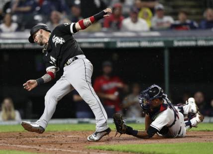 Aug 20, 2022; Cleveland, Ohio, USA; Chicago White Sox catcher Yasmani Grandal (24) is tagged out at home by Cleveland Guardians catcher Luke Maile (12) in the seventh inning at Progressive Field. Mandatory Credit: Aaron Josefczyk-USA TODAY Sports