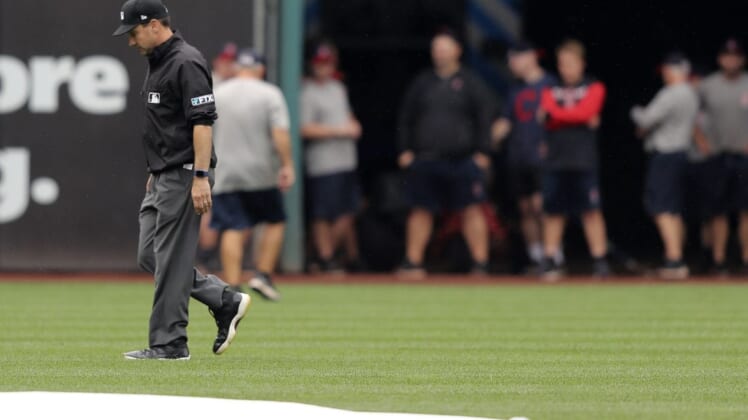 Aug 21, 2022; Cleveland, Ohio, USA; Umpire David Rackley inspects left field after a heavy rain prior to the start of the Cleveland Guardians and Chicago White Sox game at Progressive Field. Mandatory Credit: Aaron Josefczyk-USA TODAY Sports