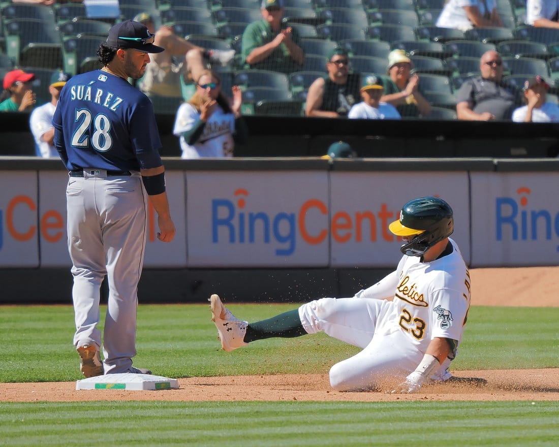 Aug 21, 2022; Oakland, California, USA; Oakland Athletics catcher Shea Langeliers (23) safe at third base below Seattle Mariners third baseman Eugenio Suarez (28) during the eighth inning at RingCentral Coliseum. Mandatory Credit: Kelley L Cox-USA TODAY Sports