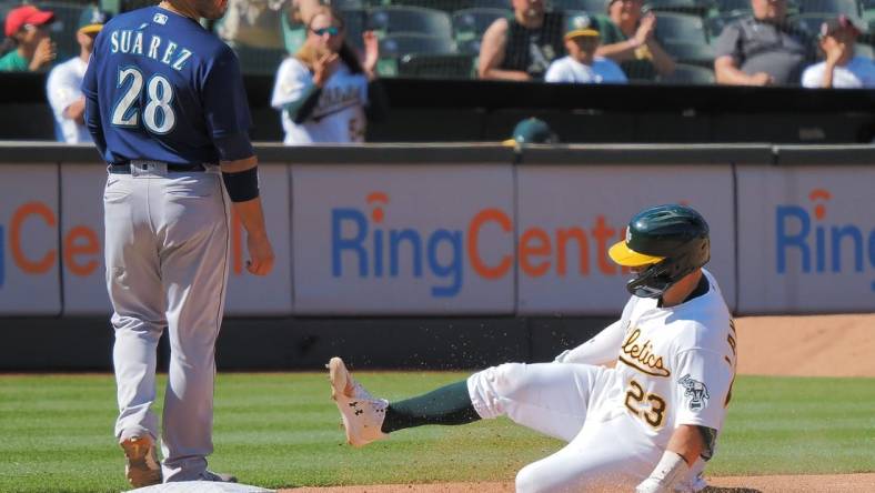 Aug 21, 2022; Oakland, California, USA; Oakland Athletics catcher Shea Langeliers (23) safe at third base below Seattle Mariners third baseman Eugenio Suarez (28) during the eighth inning at RingCentral Coliseum. Mandatory Credit: Kelley L Cox-USA TODAY Sports