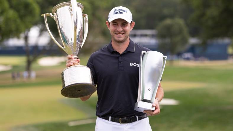 Aug 21, 2022; Wilmington, Delaware, USA; Patrick Cantlay poses with the BMW and Western Golf Association trophies after winning the BMW Championship golf tournament. Mandatory Credit: Bill Streicher-USA TODAY Sports