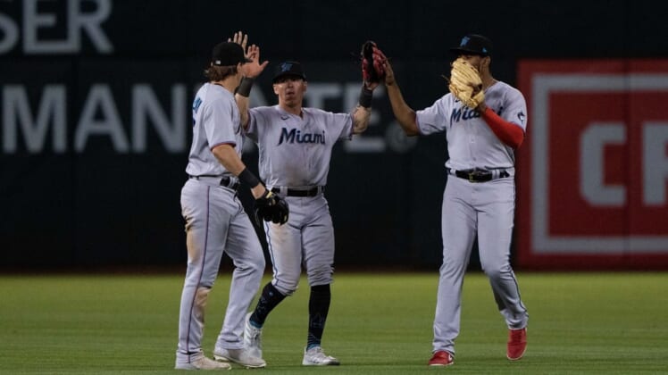 Aug 22, 2022; Oakland, California, USA; (l to r) Miami Marlins left fielder JJ Bleday (67) and center fielder Peyton Burdick (86) and right fielder Jerar Encarnacion (64) celebrate after defeating the Oakland Athletics at RingCentral Coliseum. Mandatory Credit: Stan Szeto-USA TODAY Sports