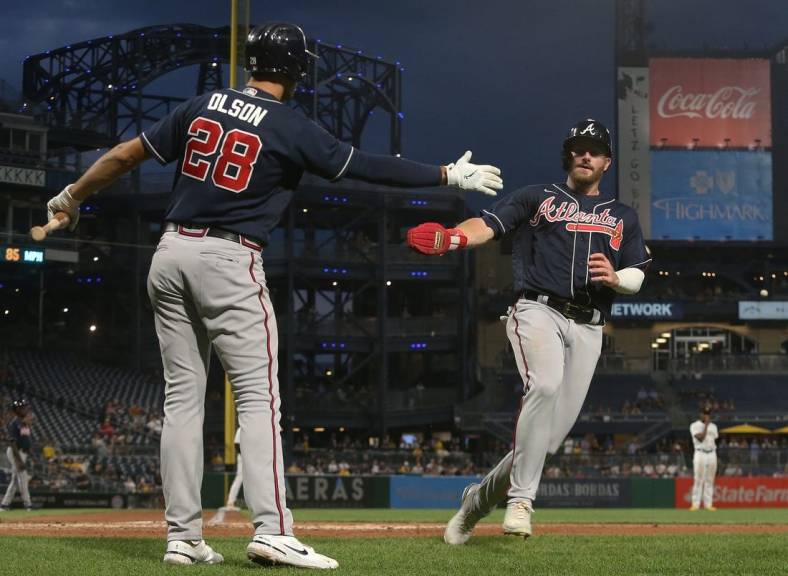 Aug 23, 2022; Pittsburgh, Pennsylvania, USA; Atlanta Braves first baseman Matt Olson (28) greets left fielder Robbie Grossman (right) after Grossman scored a run against the Pittsburgh Pirates during the fifth inning at PNC Park. Mandatory Credit: Charles LeClaire-USA TODAY Sports