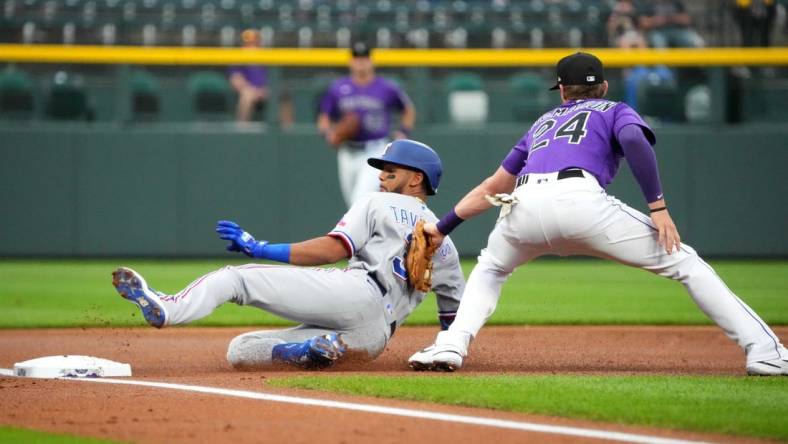 Aug 23, 2022; Denver, Colorado, USA; Colorado Rockies third baseman Ryan McMahon (24) tags out Texas Rangers center fielder Leody Taveras (3) in the first inning at Coors Field. Mandatory Credit: Ron Chenoy-USA TODAY Sports