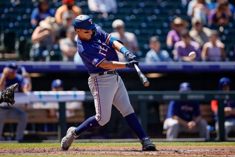 Aug 24, 2022; Denver, Colorado, USA; Texas Rangers first baseman Mark Mathias (9) hits a three RBI double in the second inning against the Colorado Rockies at Coors Field. Mandatory Credit: Isaiah J. Downing-USA TODAY Sports