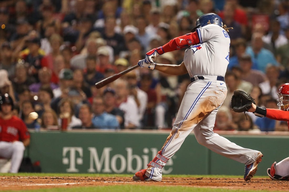 Aug 24, 2022; Boston, Massachusetts, USA; Toronto Blue Jays first baseman Vladimir Guerrero (27) hits an RBI during the fifth inning against the Boston Red Sox at Fenway Park. Mandatory Credit: Paul Rutherford-USA TODAY Sports