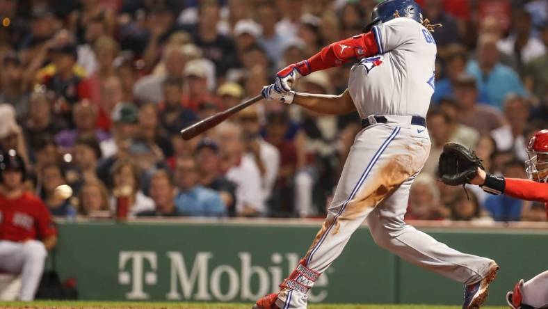 Aug 24, 2022; Boston, Massachusetts, USA; Toronto Blue Jays first baseman Vladimir Guerrero (27) hits an RBI during the fifth inning against the Boston Red Sox at Fenway Park. Mandatory Credit: Paul Rutherford-USA TODAY Sports