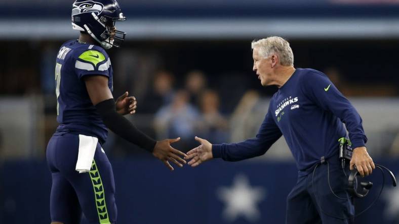 Aug 26, 2022; Arlington, Texas, USA; Seattle Seahawks head coach Pete Carroll (right) congratulates quarterback Geno Smith (7) as he comes off  the field in the first quarter against the Dallas Cowboys at AT&T Stadium. Mandatory Credit: Tim Heitman-USA TODAY Sports